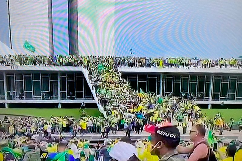 Em alguns minutos, eles invadiram a área do Congresso Nacional e subiram no teto do prédio do Poder Legislativo brasileiro.